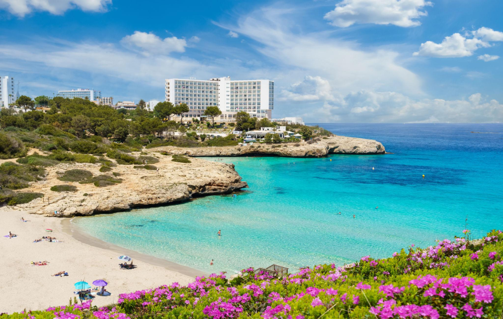 Cala Domingo beach in Mallorca with sandy shore, turquoise water and resort facilities