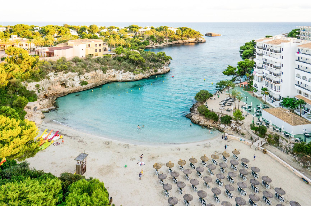 Cala Ferrera beach in Mallorca with turquoise water, sandy shore and rocky cliffs