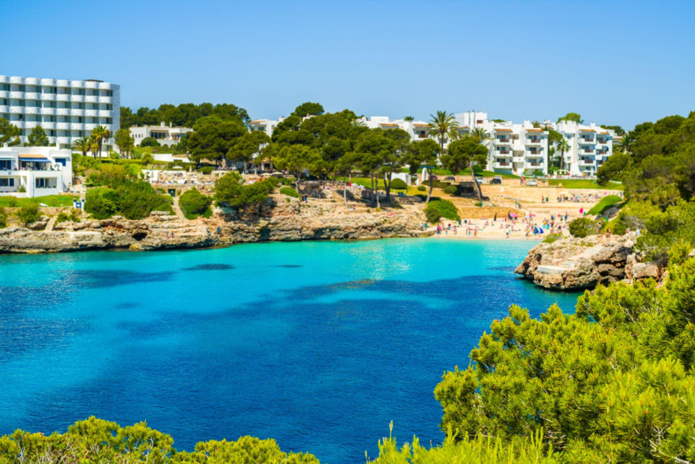 Cala Esmeralda beach in Cala d’Or with pale sand, clear water and rocky coastline