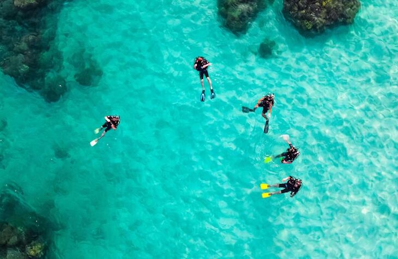 Diver exploring rocky underwater scenery near Cala d’Or