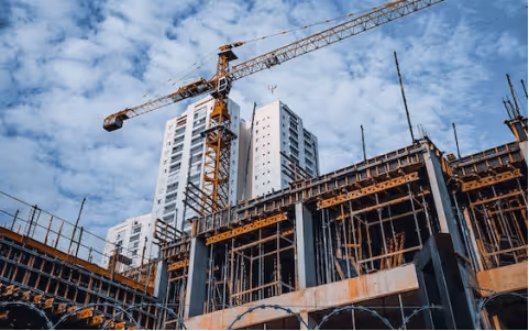 A crane is standing on top of a building under construction.
