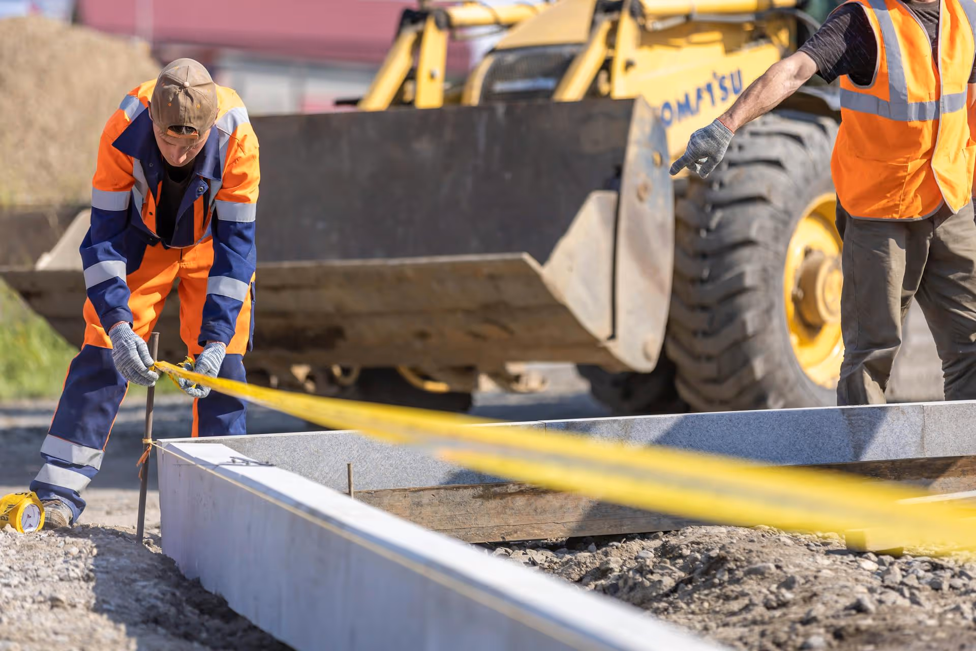 Worker measuring groundworks
