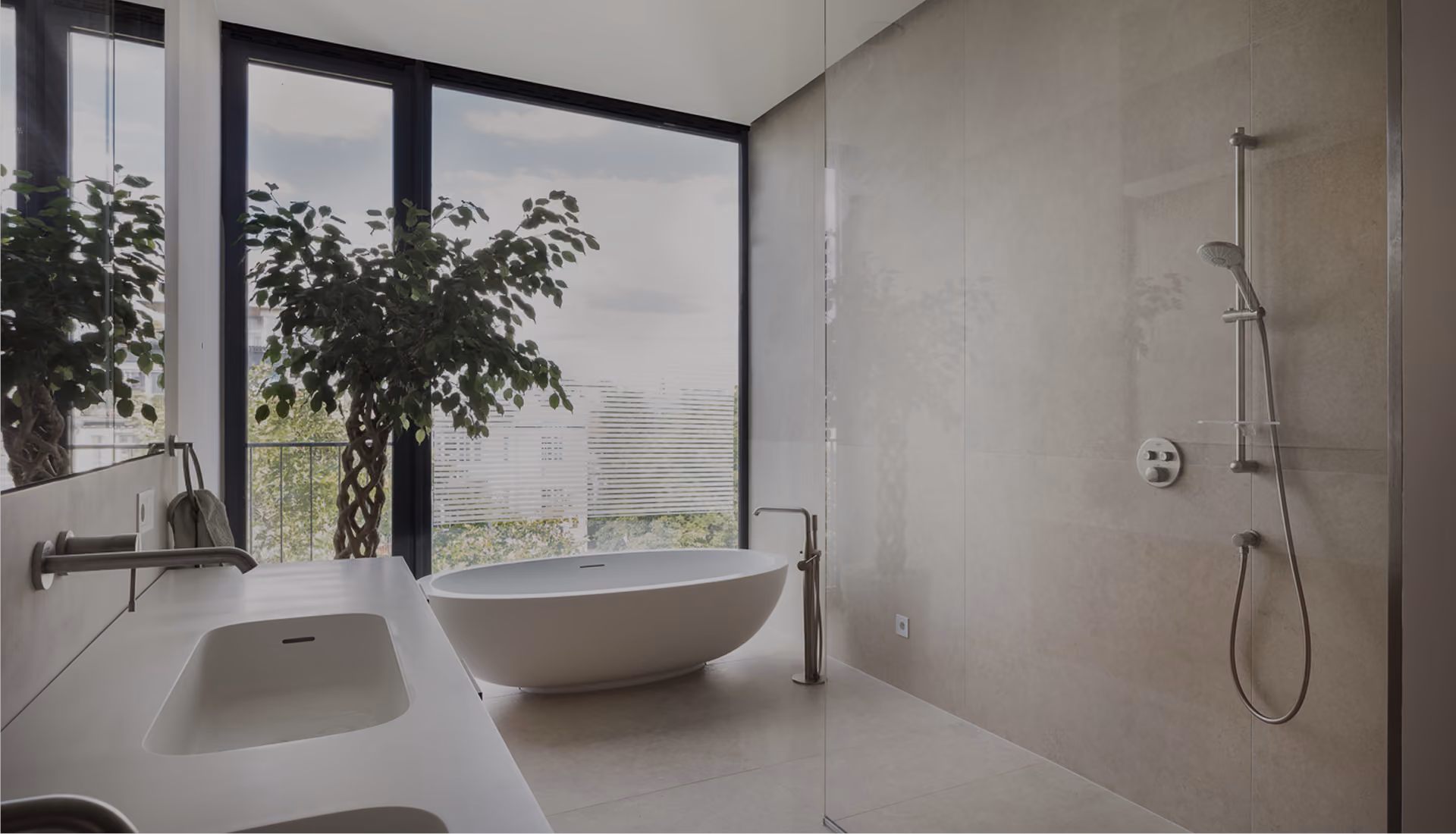 Minimalistisches Badezimmer mit freistehender Badewanne, offener Dusche und raumhoher Fensterfront mit Blick über die Stadt
