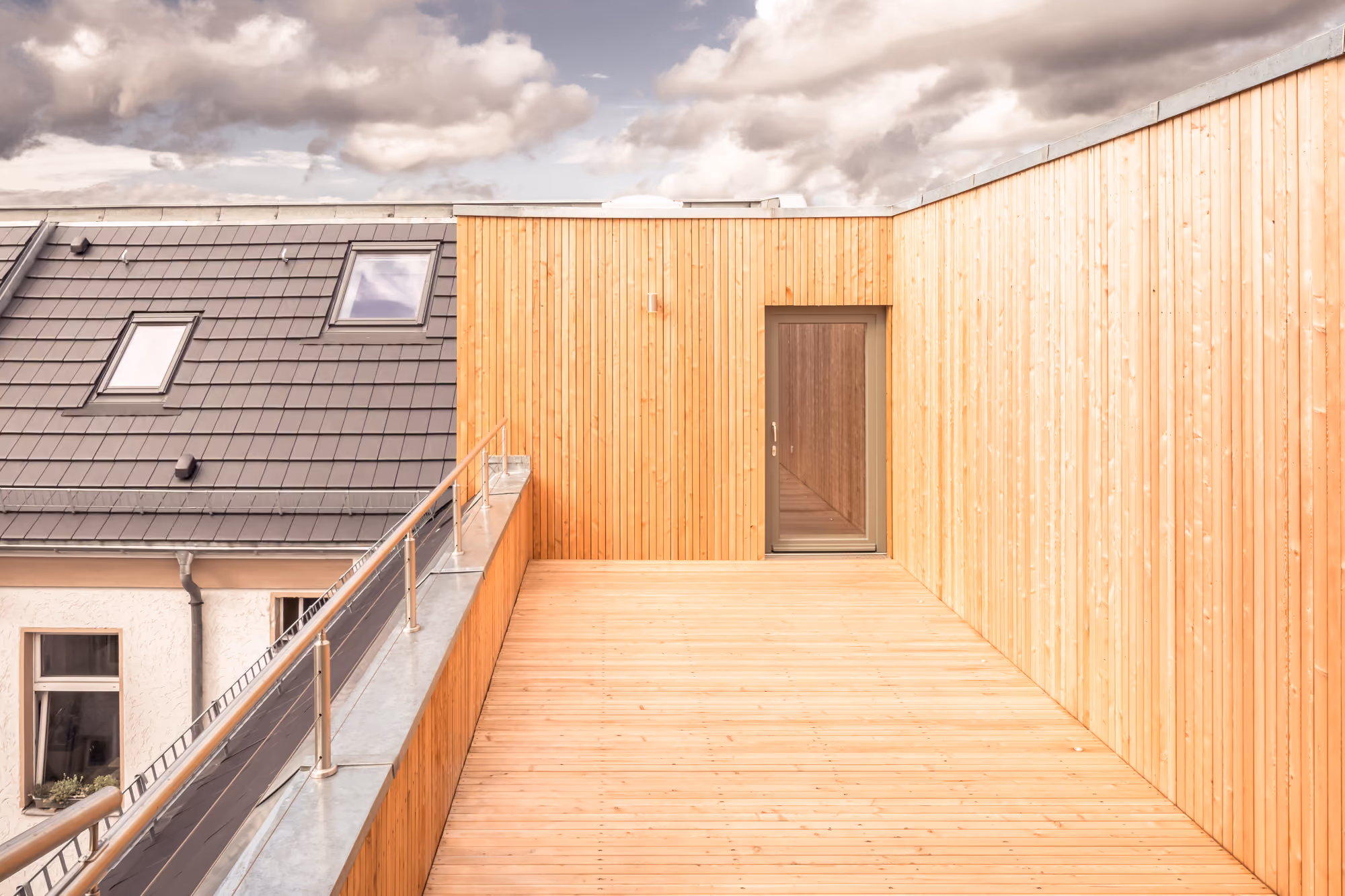 Dachterrasse der Aufstockung mit Lärchenholzbelag und -fassade über den Berliner Dächern