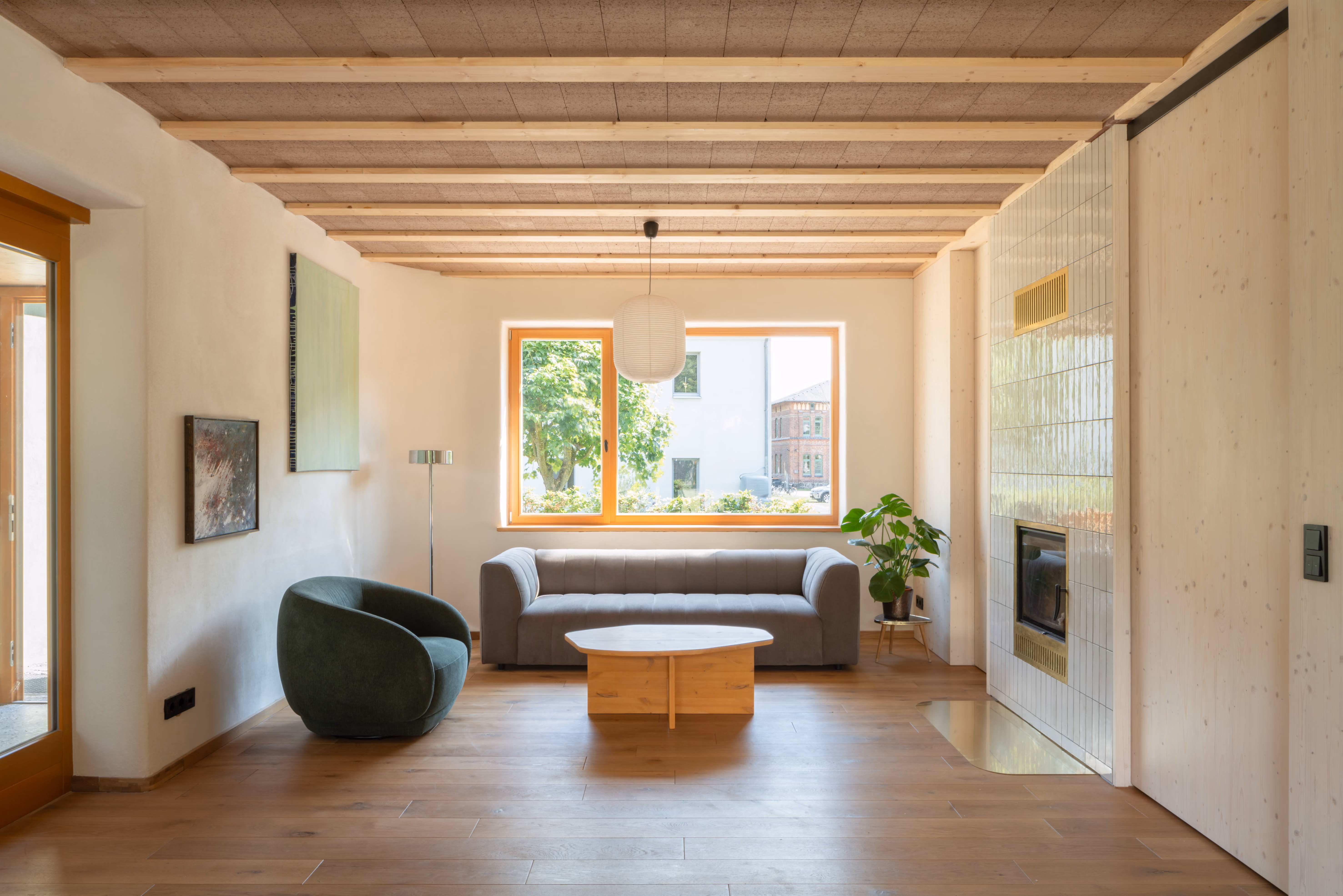 Offener Wohnraum mit Holzdecke und großen Fenstern, natürliche Materialien, Daniel Boepple Architekt
