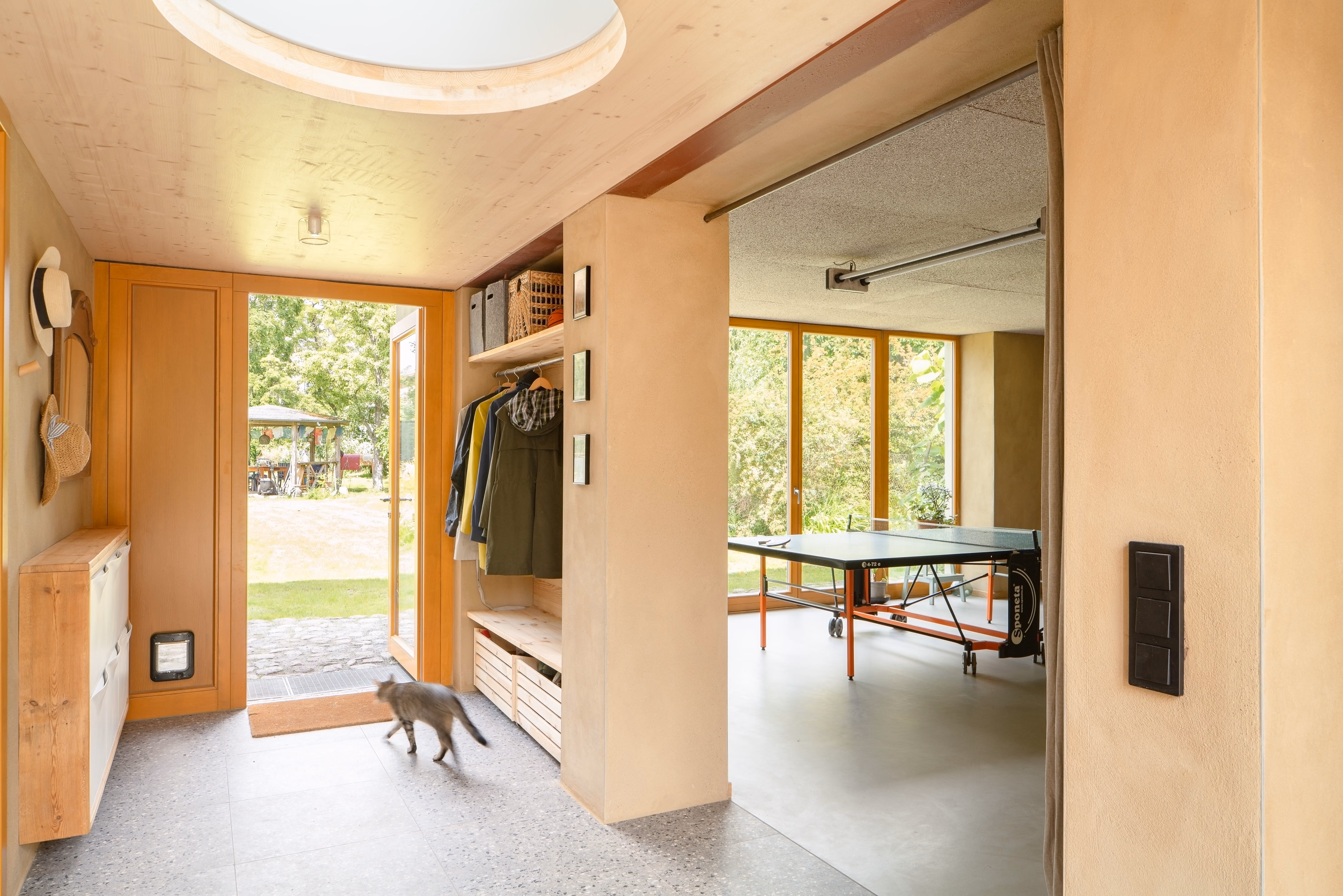 Heller Eingangsbereich mit Sichtbeton und Holzelementen, Holz-Stroh-Lehm-Haus Daniel Boepple Architekt