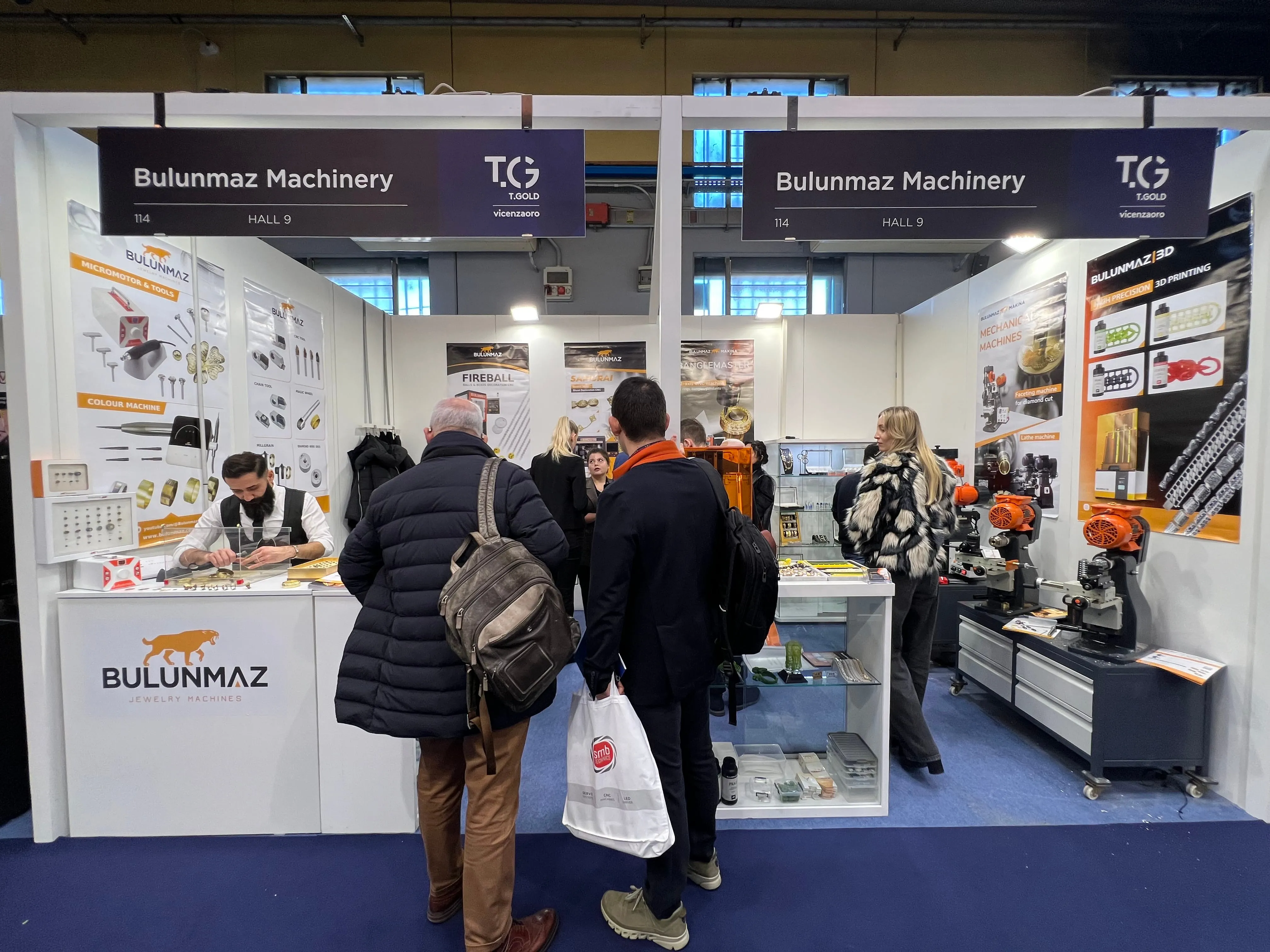 Trade show booth for Bulunmaz Machinery with people viewing jewelry machines and tools displayed.