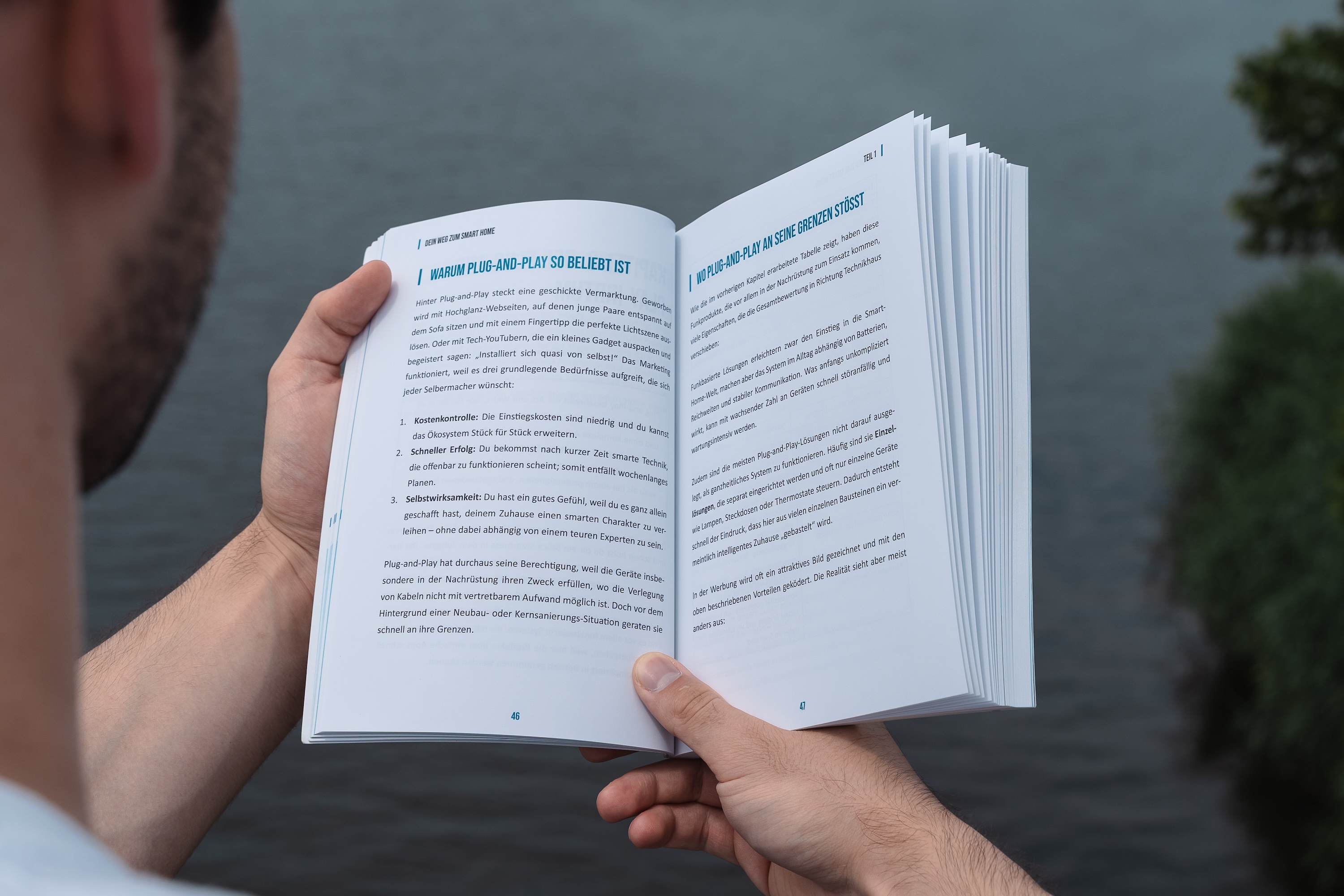 Leser blättert im aufgeschlagenen Buch "Dein Weg zum Smart Home"