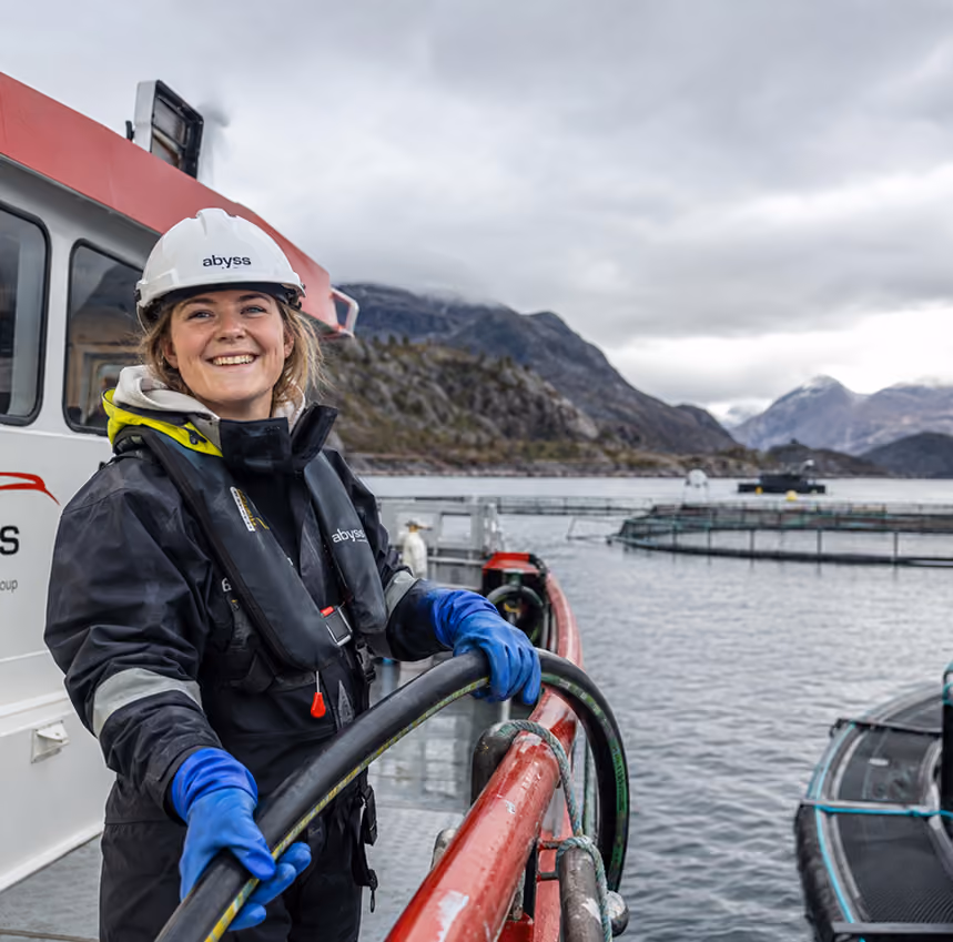 En Abyss-medarbeider arbeider med slange ved et oppdrettsanlegg.