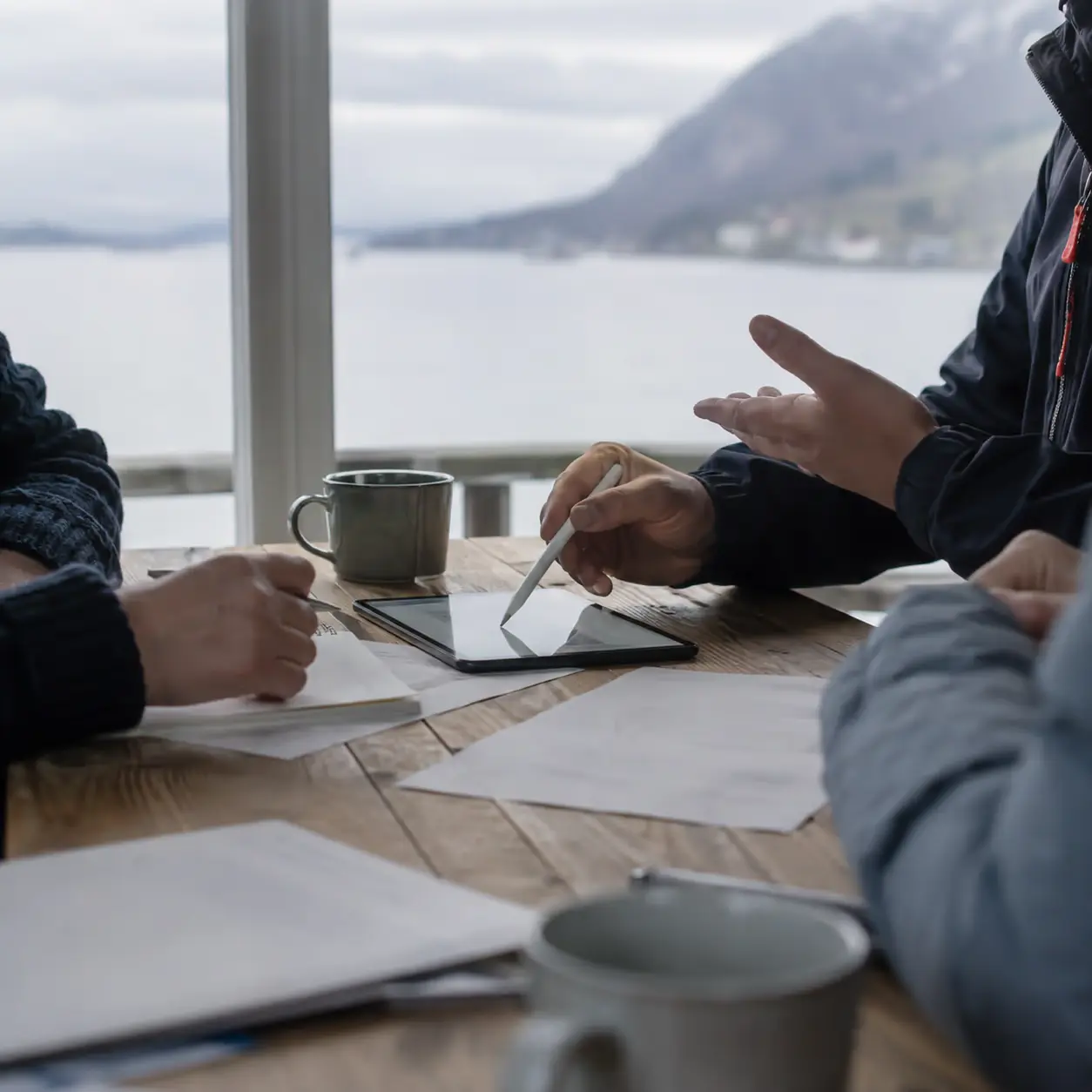 Representanter gjennomgår en sponsorsøknad sammen rundt et bord.