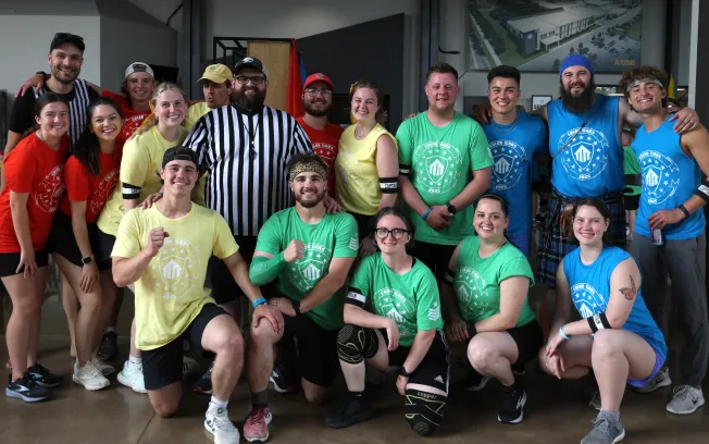 Group of young people in colored team shirts posing with a referee at a Living Stones youth event.