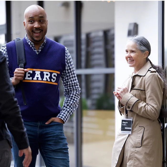 Man and woman laughing together while greeting one another at Living Stones church.