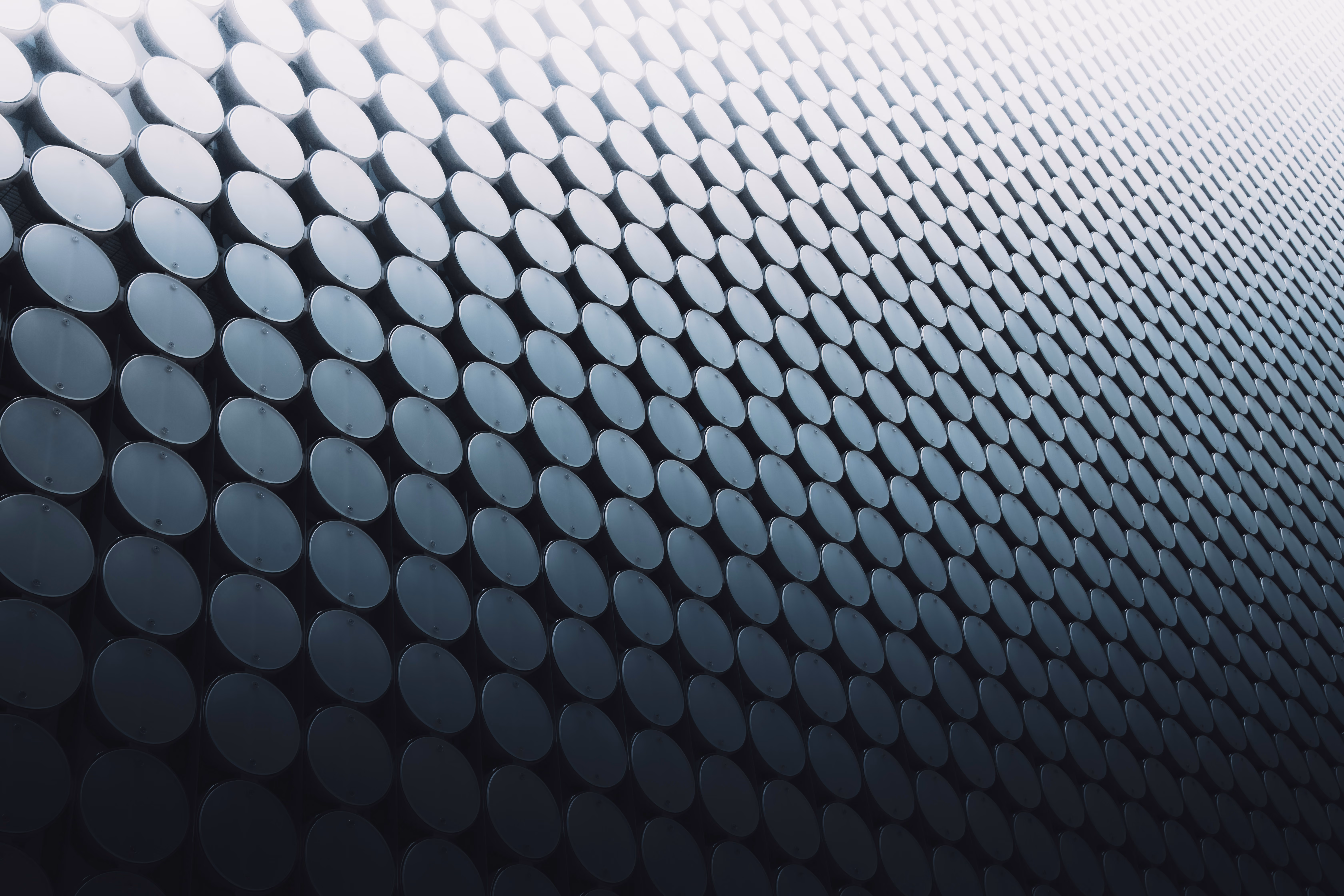 Close-up of rows of dark metal cylinders arranged in a repeating pattern
