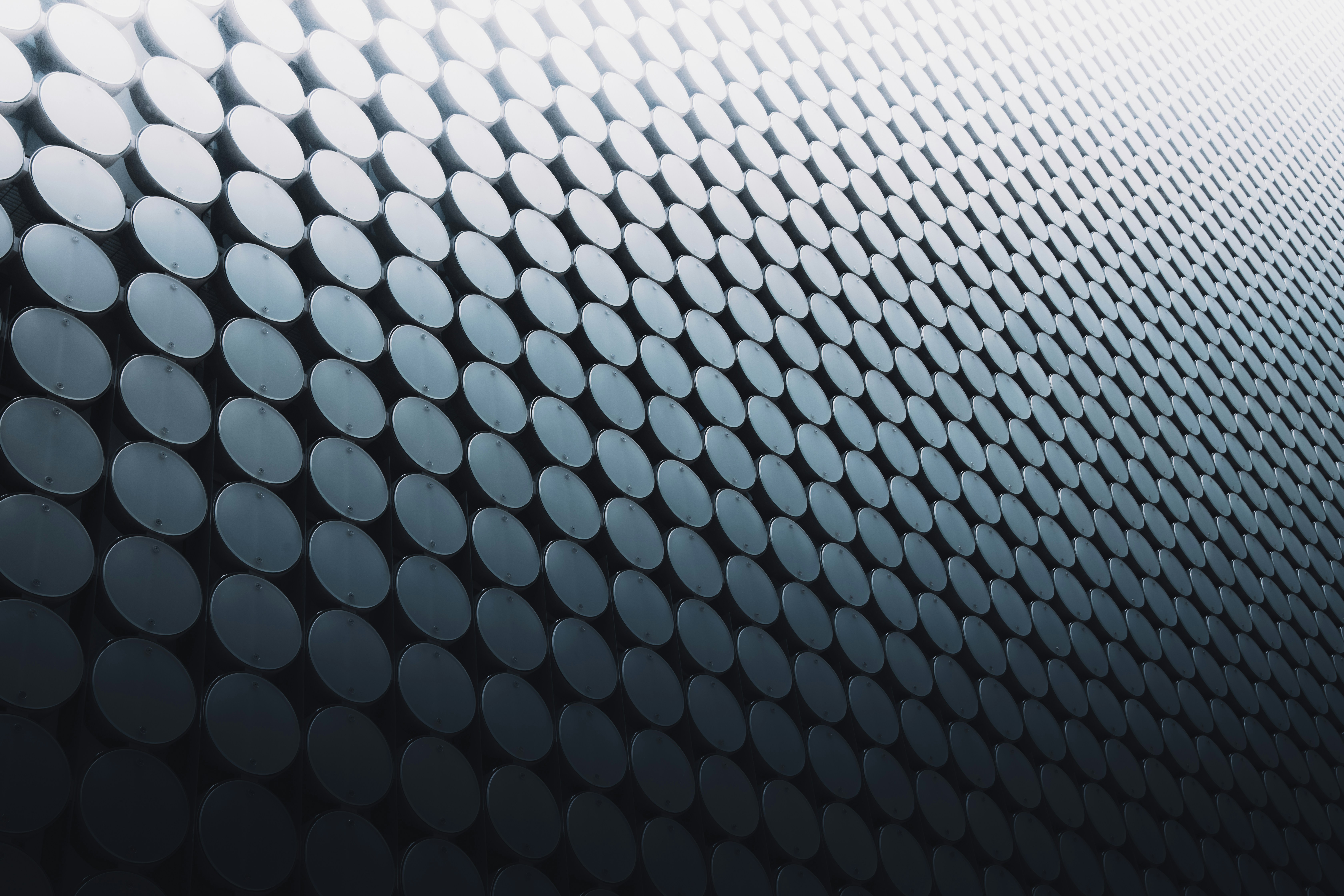 Close-up of rows of dark metal cylinders arranged in a repeating pattern