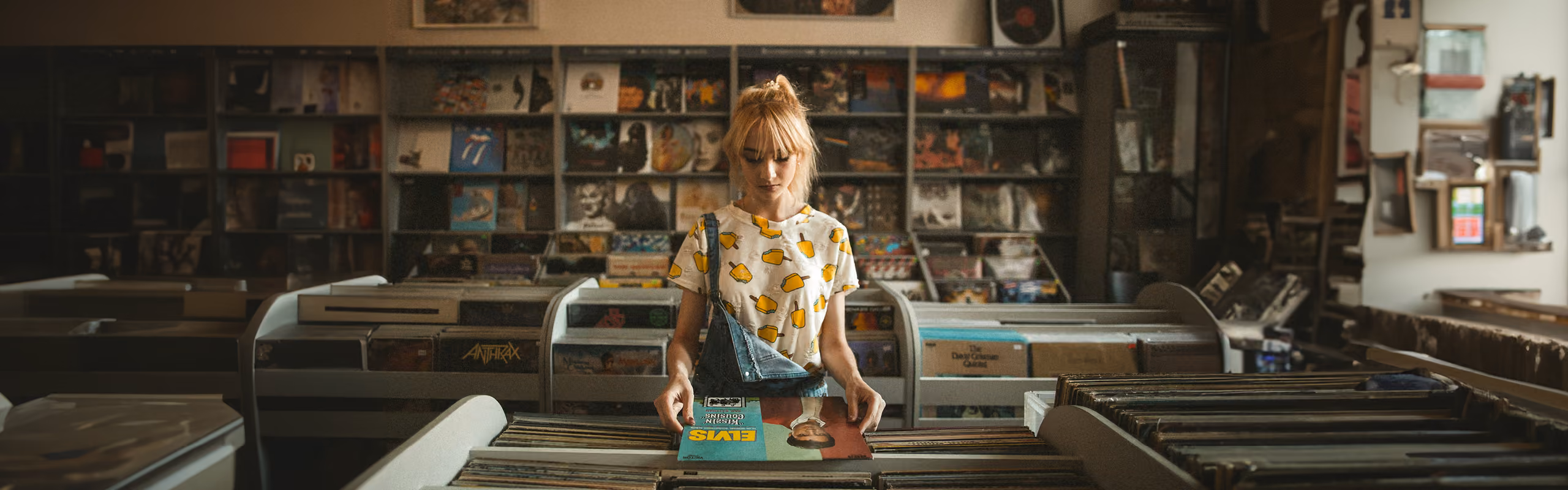 Someone in a record store looking at 2 records