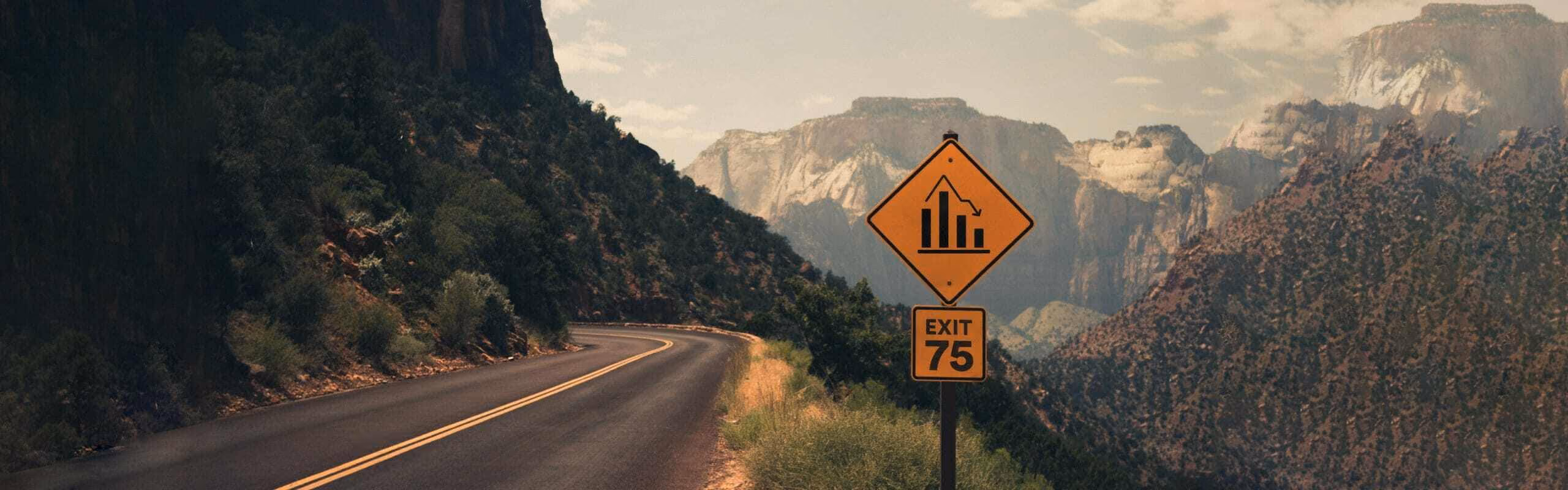 An exit sign on a road high up in the mountanside