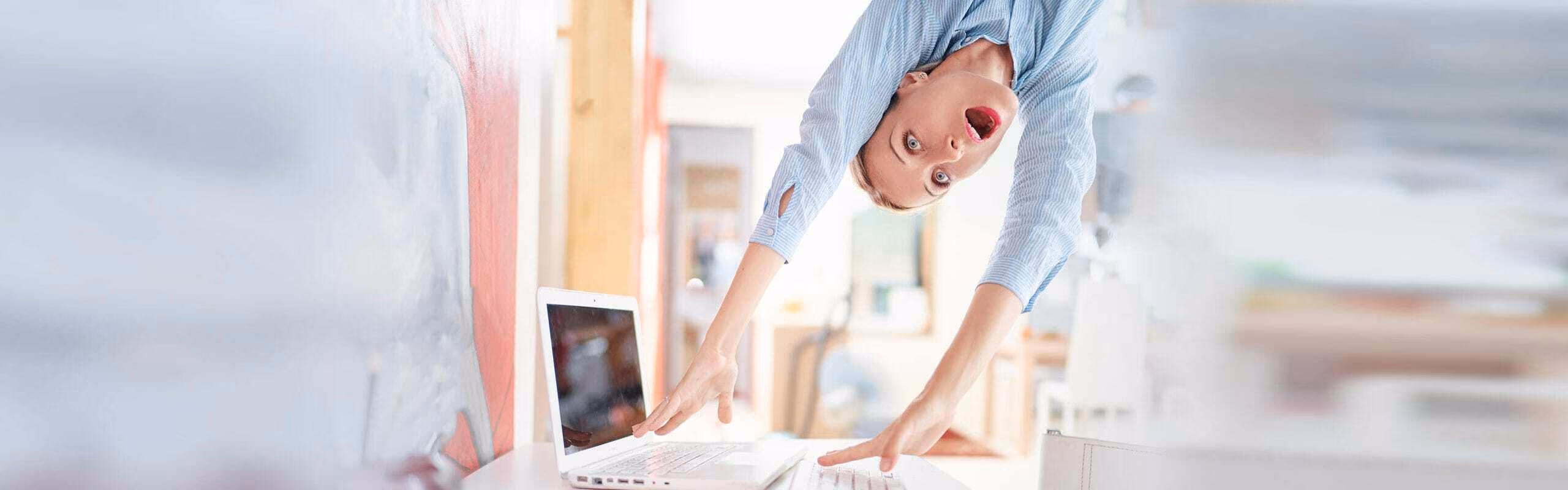 Person doing a hand stand next to their laptop