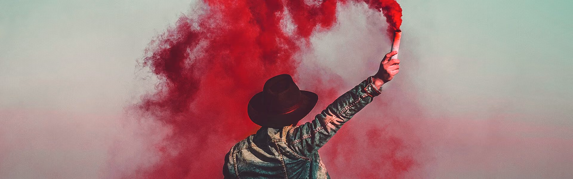 Person in cowboy hat holding a flare