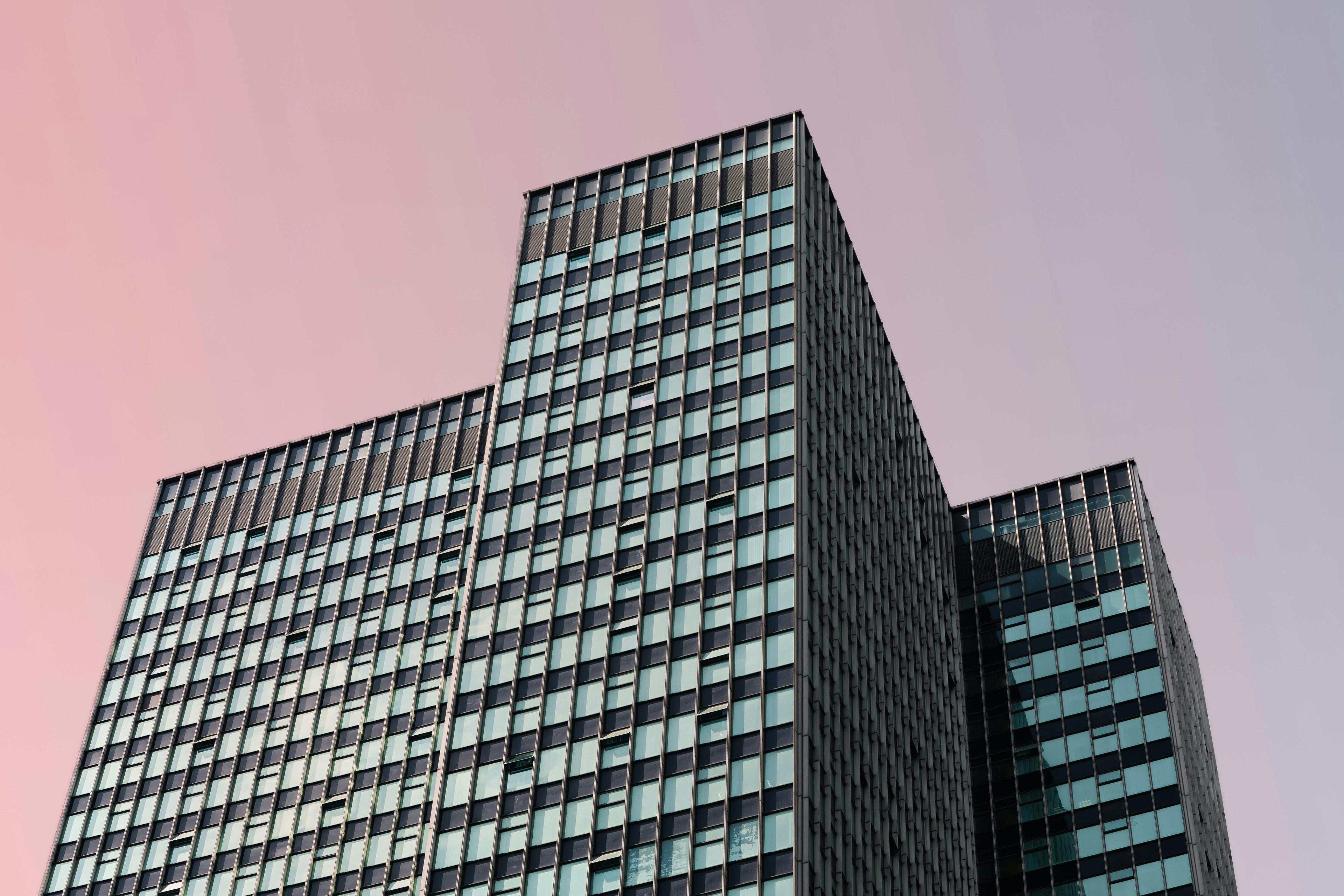 3 corporate buildings set against a sunset sky