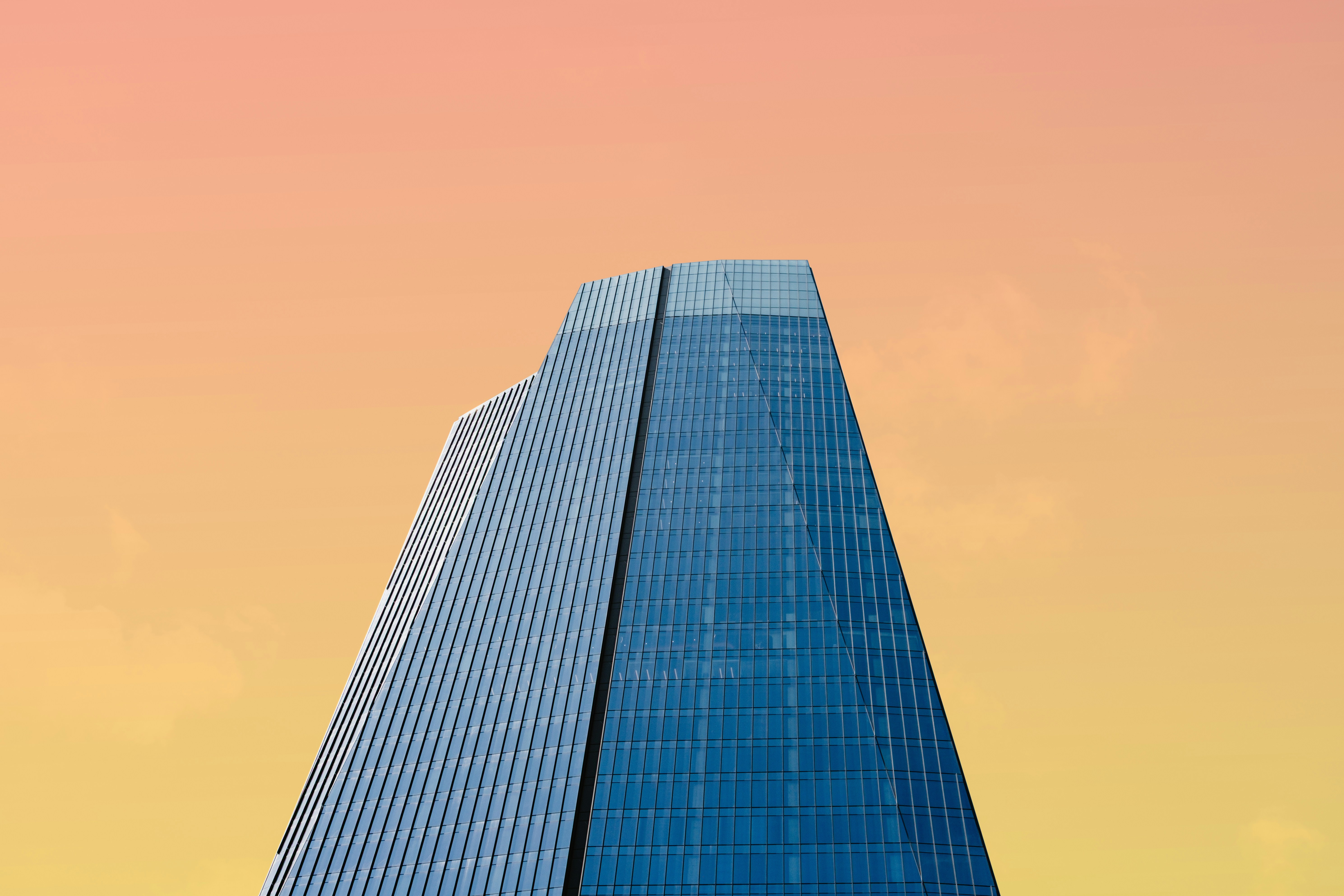 Tall corporate office building set against an orange sunsetting sky