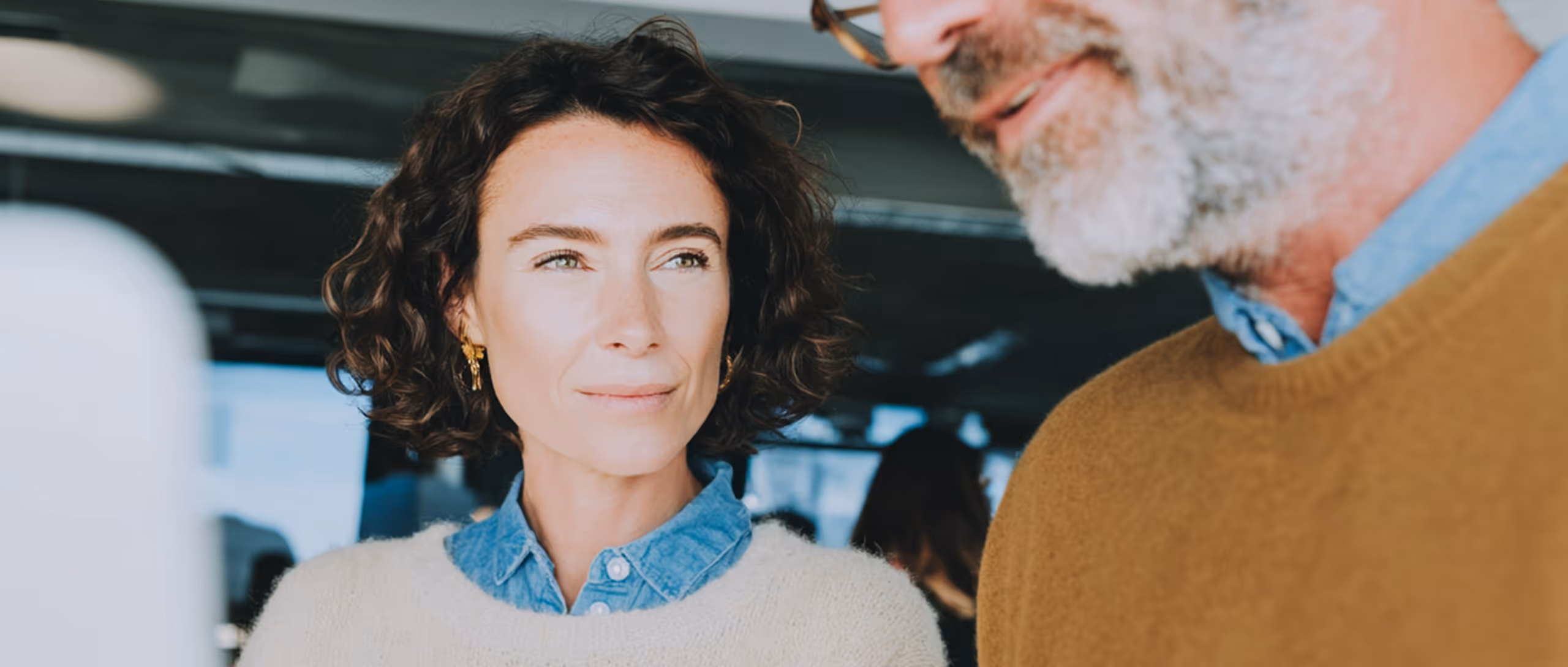 Une femme et un homme souriants discutant dans un bureau.