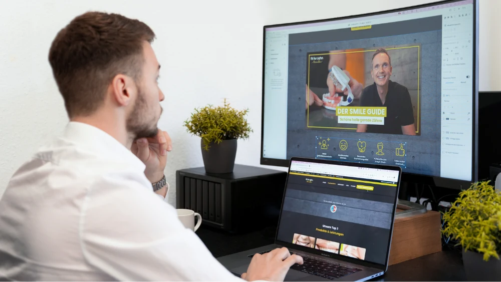 Arbeit an der Website eines Kunden an Monitor und Laptop, um die Sichtbarkeit bei Google für Erlangen zu verbessern