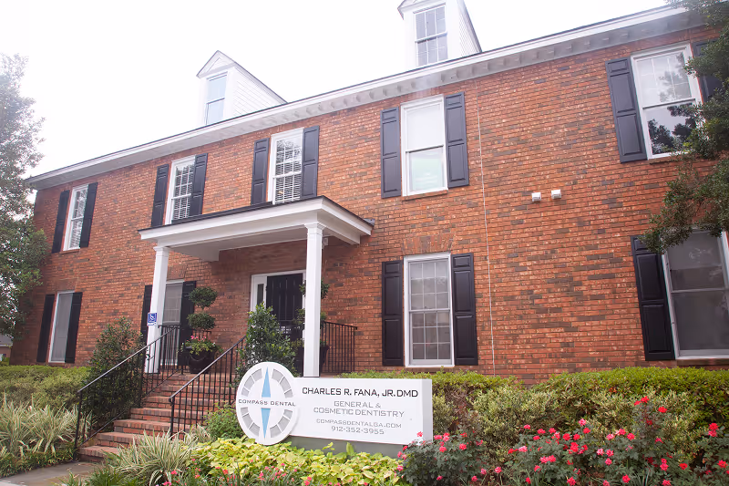 Two-story brick dental office with black shutters and a sign for Charles R. Fana, Jr. DMD general dentistry.