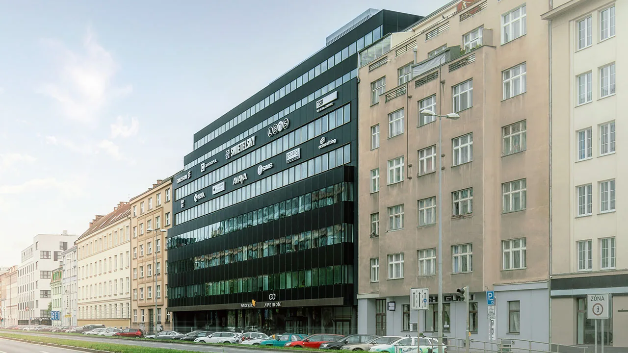 Kancelářská budova Apeiron s tmavou skleněnou fasádou v ulici