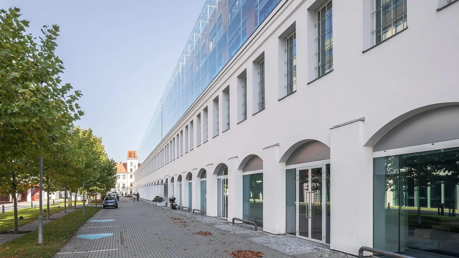 Fasáda budovy Corso Karlín s obloukovou pasáží v přízemí