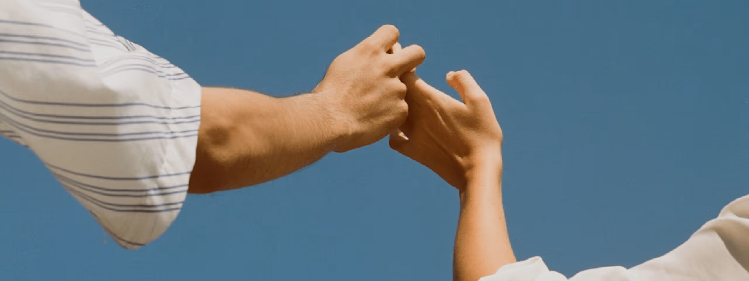Two people reaching toward each other, representing connection and support throughout care
