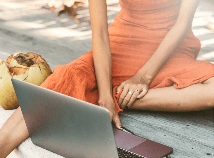 Woman working on laptop while seated outdoors