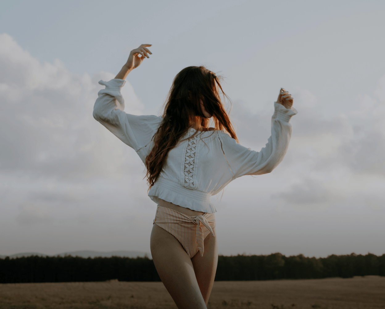 Woman moving outdoors with her arms raised