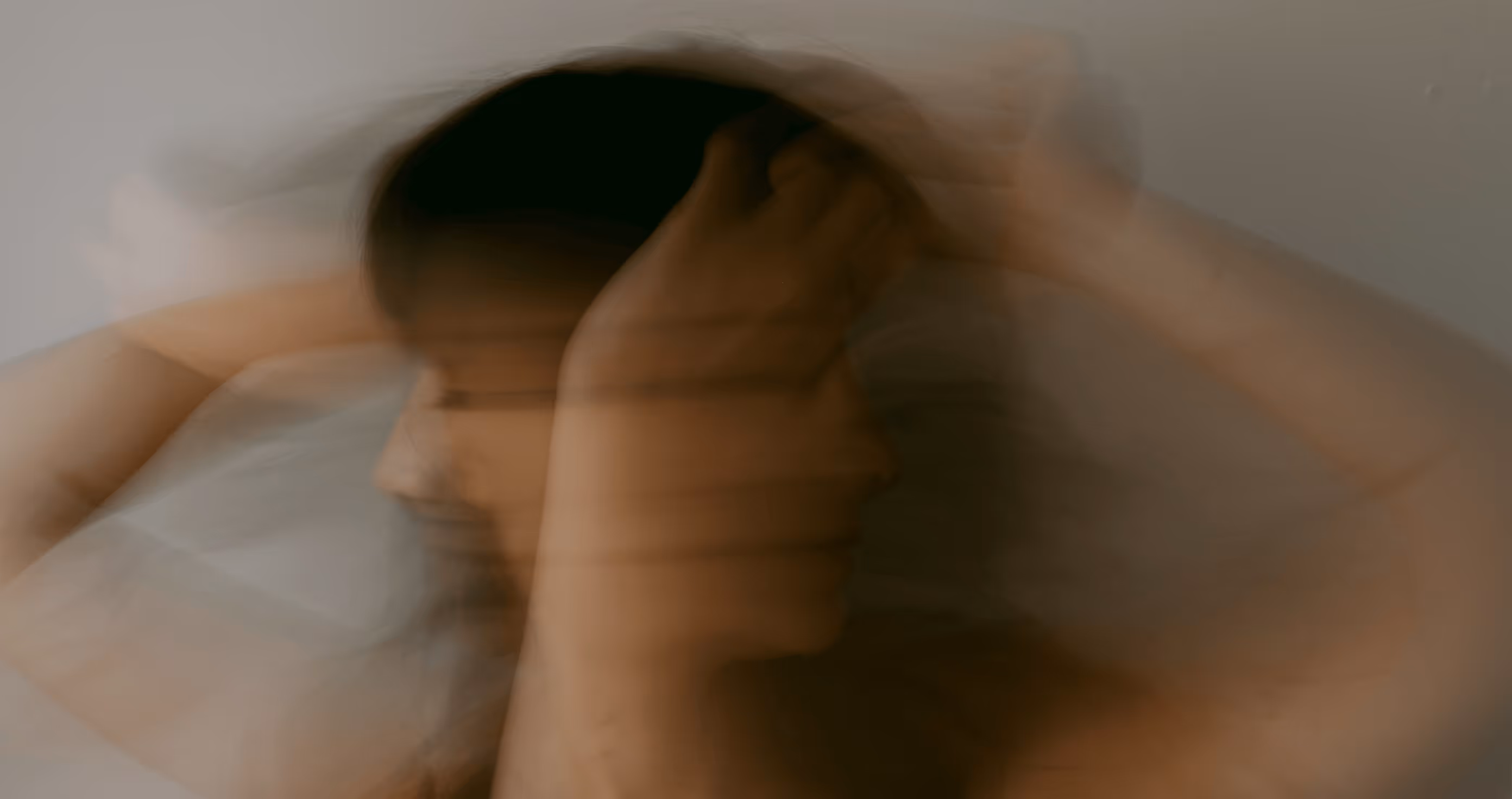 Person holding their head, representing mental health challenges and emotional distress