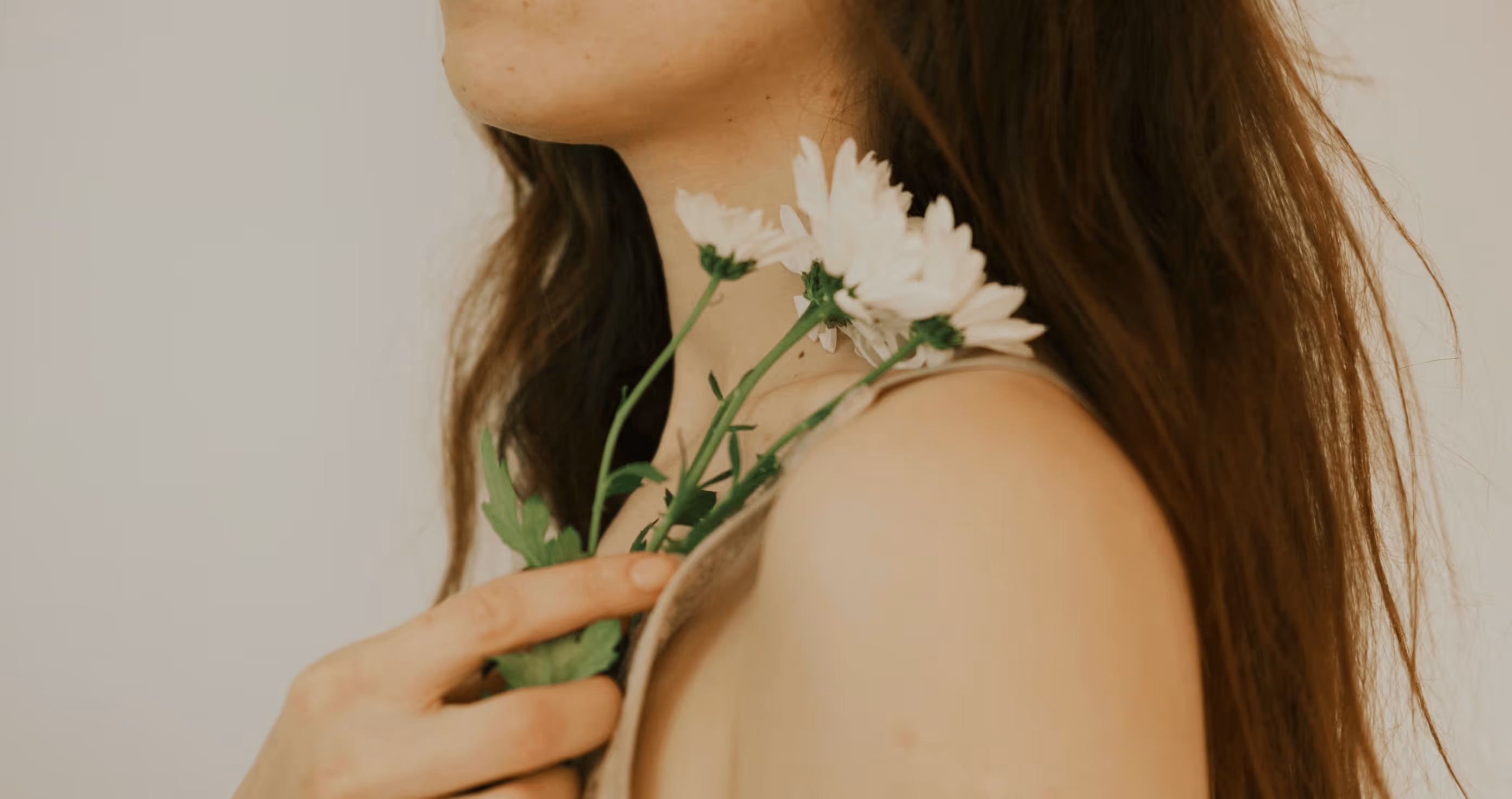 Person holding a white flower against their shoulder