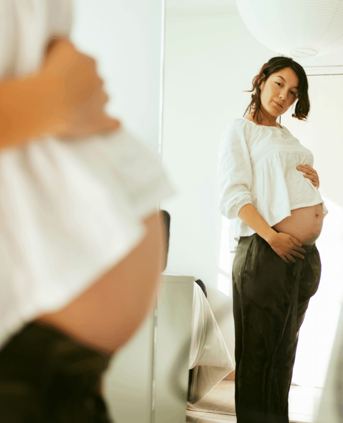 Pregnant person standing in front of a mirror