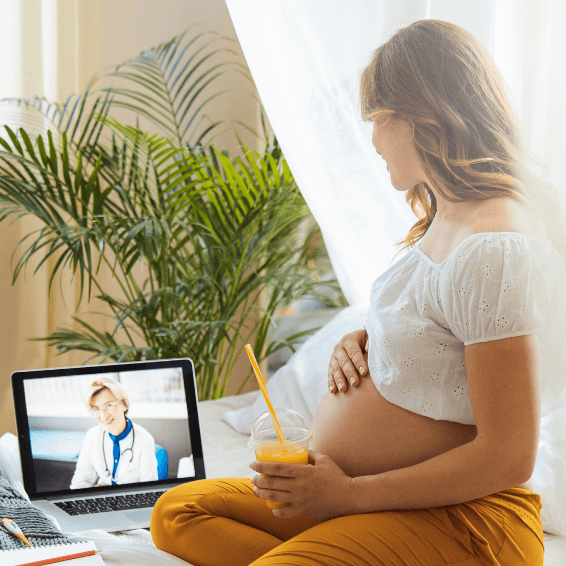 Pregnant person attending a virtual healthcare appointment from home