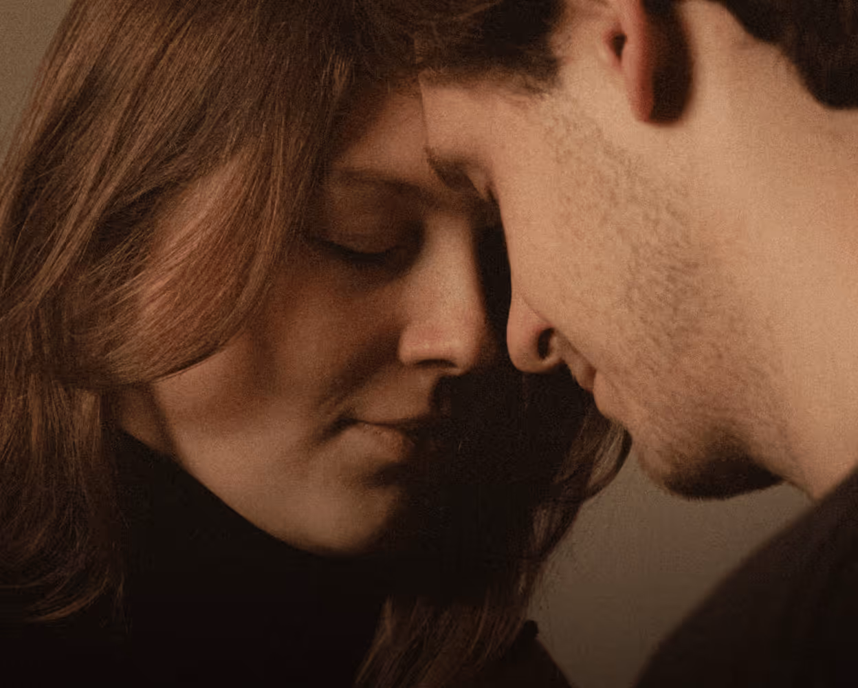 Two people leaning their foreheads together
