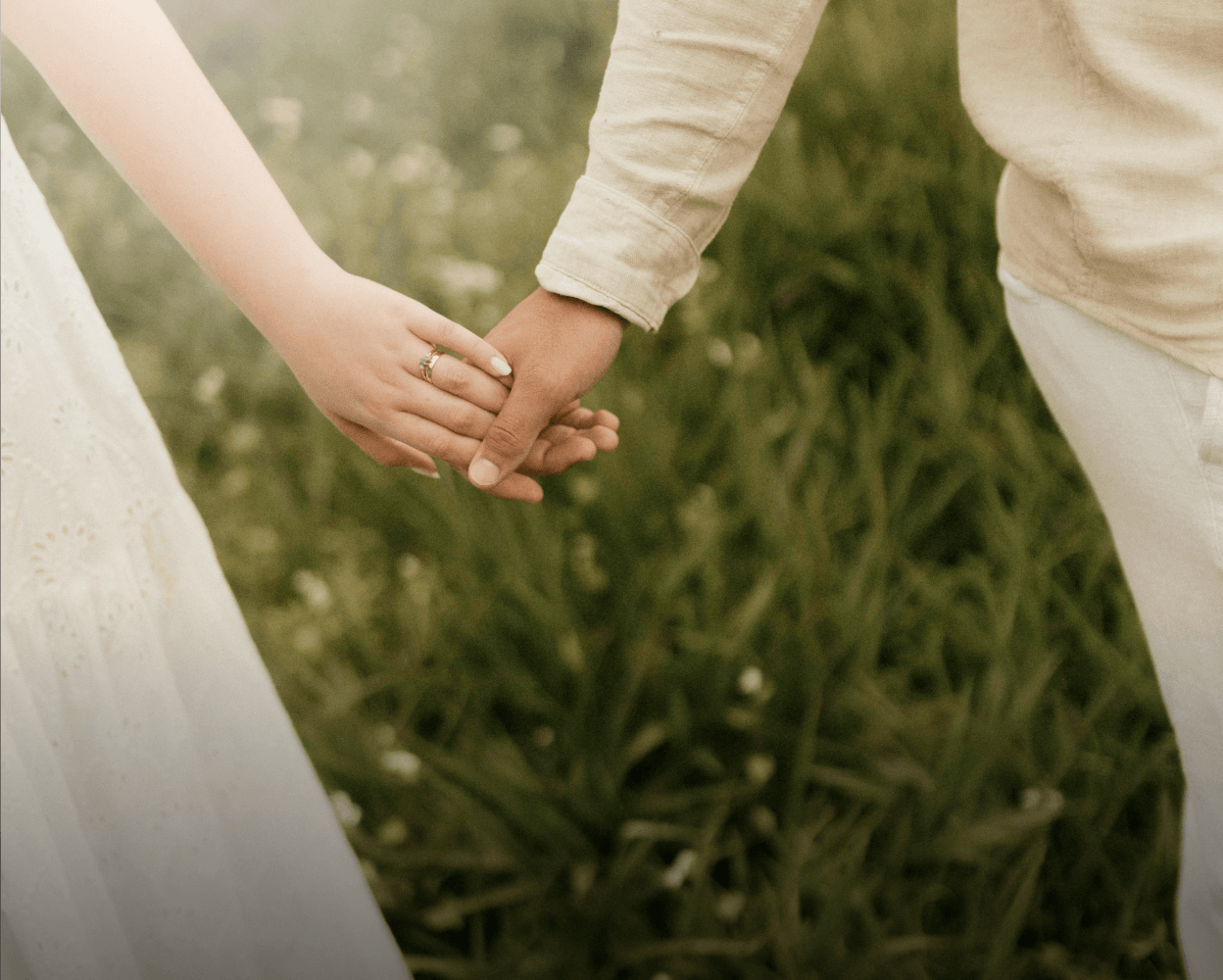 Two people holding hands outdoors