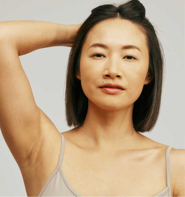 Person raising an arm while looking toward the camera