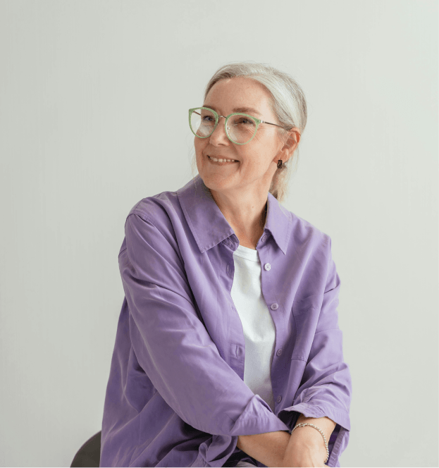Person seated and smiling while wearing glasses