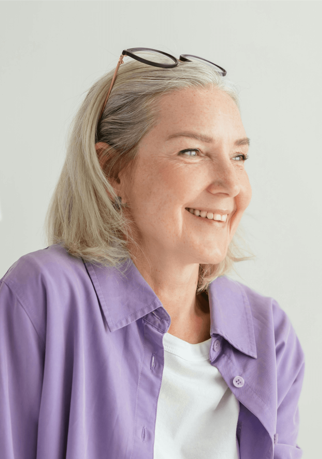 Person seated and smiling while wearing glasses