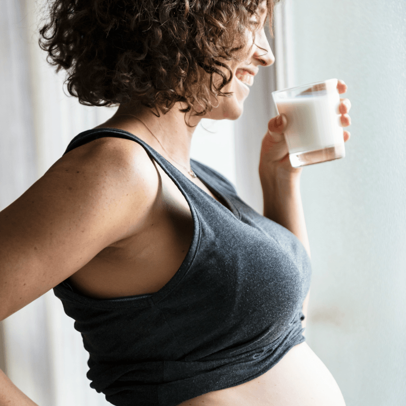 Pregnant woman holding a mug and looking out a window