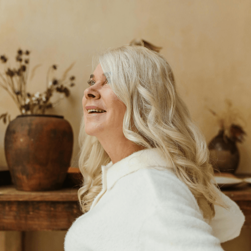 Woman smiling in a warm indoor setting