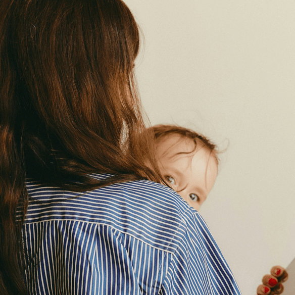 Parent holding a child while using a tablet
