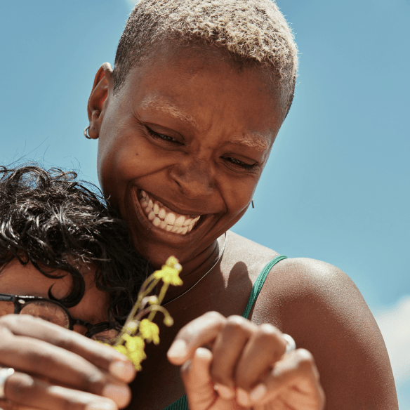 Woman smiling while spending time with a child outdoors