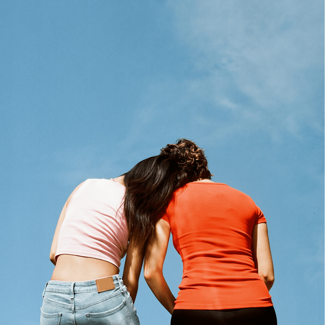 Two people leaning on each other outdoors, representing collaborative and integrated care
