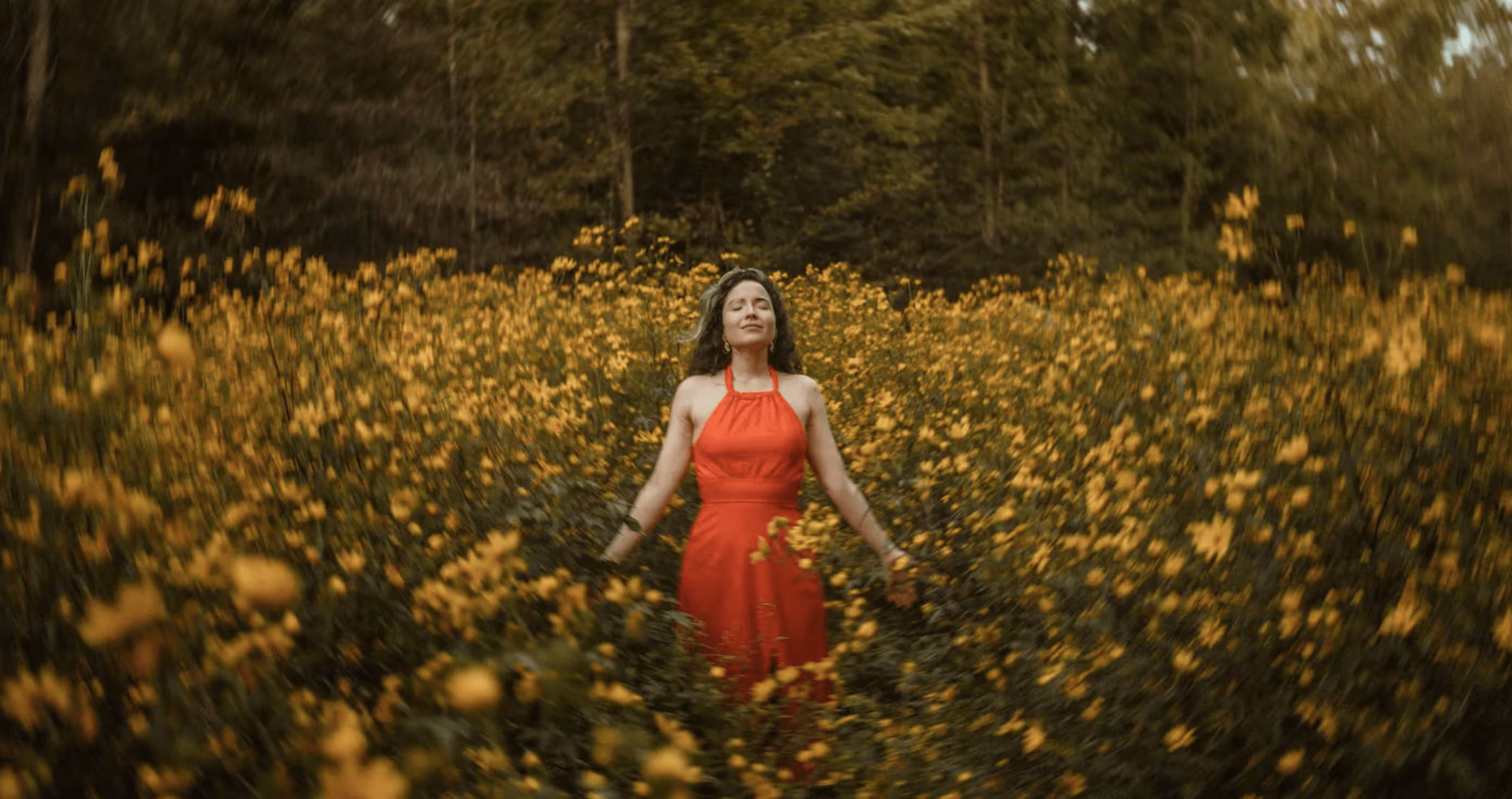 Woman standing in a field of yellow flowers
