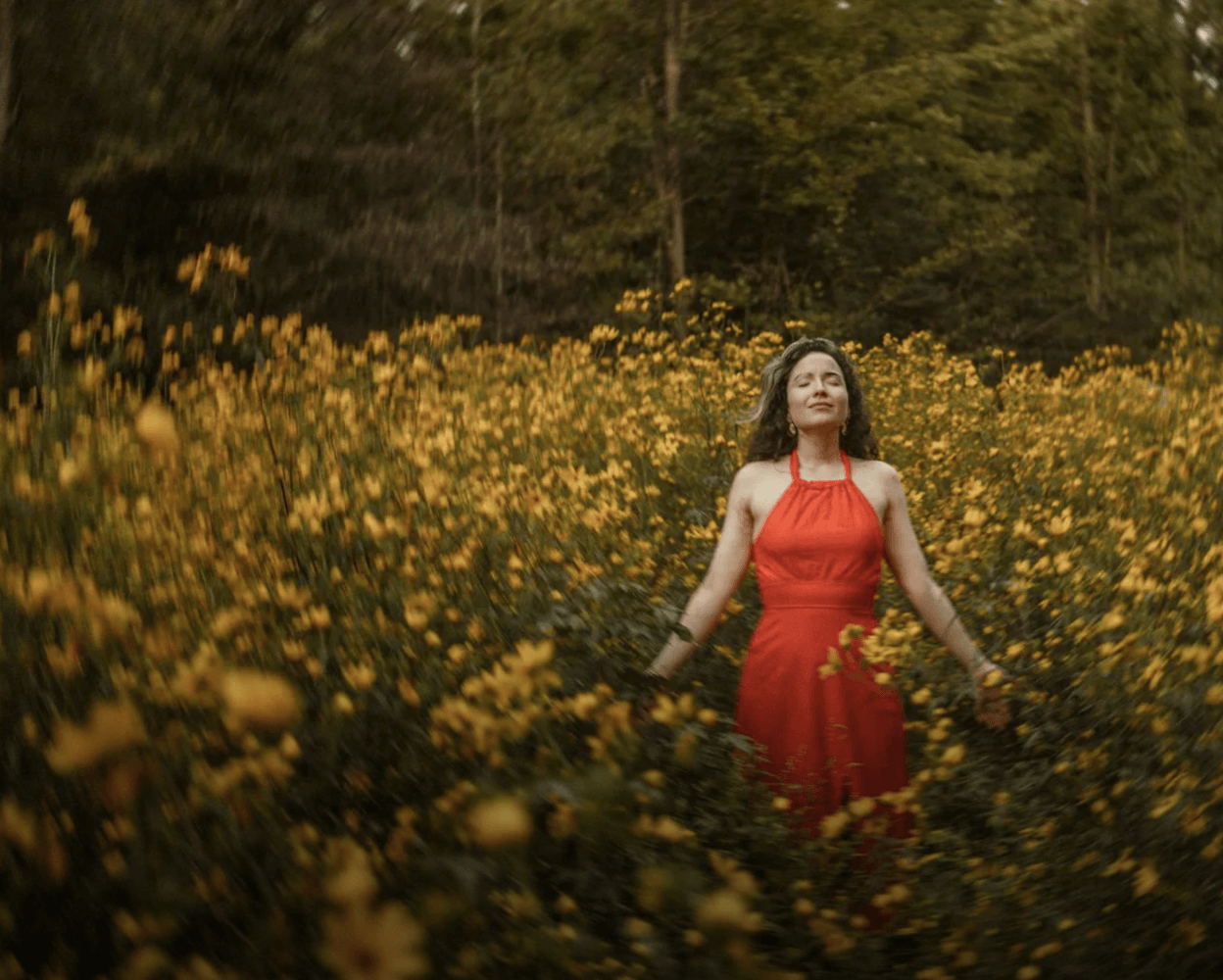 Woman standing in a field of yellow flowers