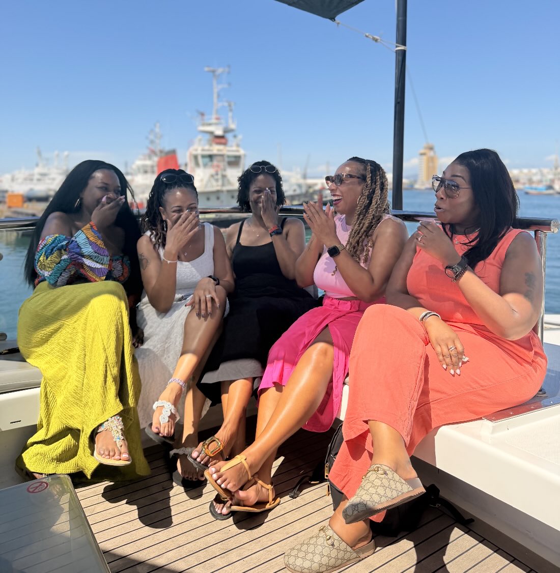A group of women laughing together aboard a yacht in South Africa.
