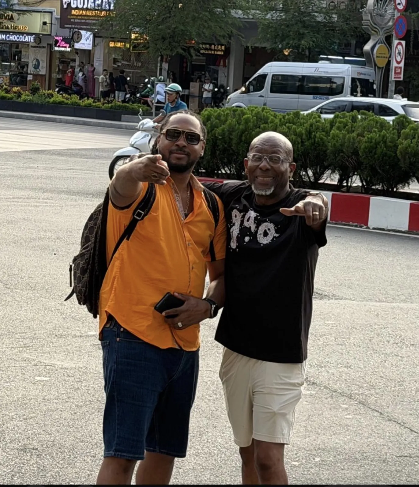 Two Haitian Nomad travelers in Vietnam pointing at the camera